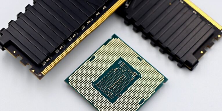 A CPU and RAM sticks displayed on a white surface, showcasing computer hardware components featured image