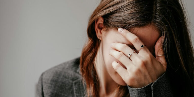 a woman covering her face with her hands FEATURED IMAGE