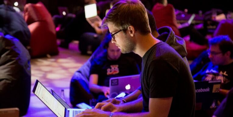 man using laptop in front of brown chair FEATURED IMAGE