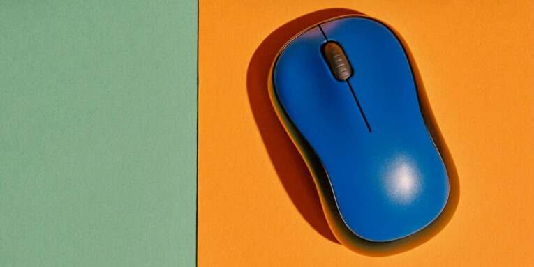 a blue computer mouse on an orange surface FEATURED IMAGE