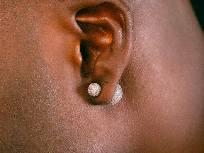 close up of a pearl earring in a dark earlobe