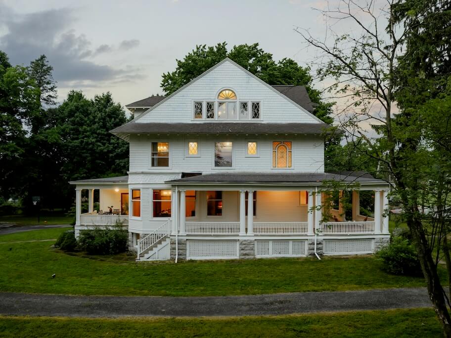 a large white house sitting on top of a lush green field