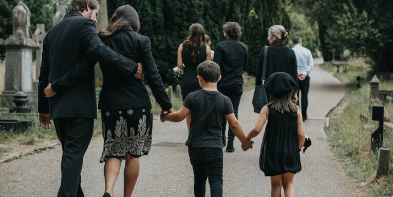 grieving family walking through a cemetery FEATURED IMAGE