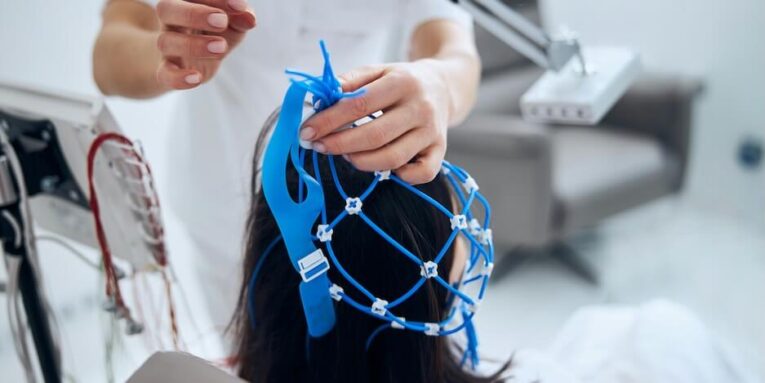 woman taking the silicone cap off the dark haired patient head after the medical procedure FEATURED IMAGE
