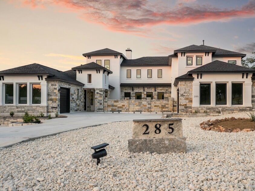 modern luxury home with stone accents at sunset
