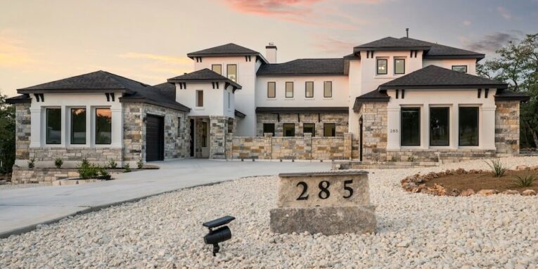 modern luxury home with stone accents at sunset FEATURED IMAGE