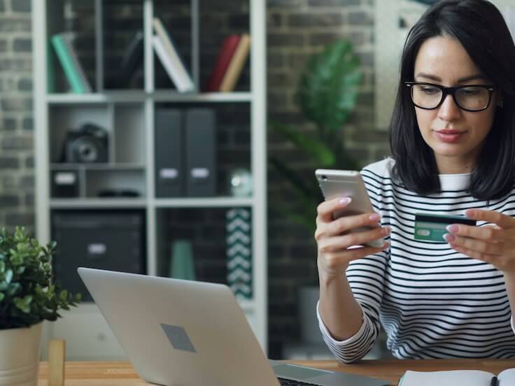 a woman sitting at a table looking at her cell phone