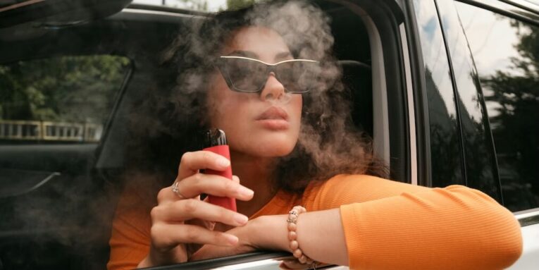 a woman sitting in a car smoking FEATURED IMAGE