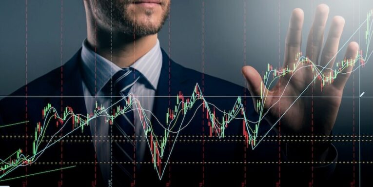 smart caucasian businessman hand touch invisible stock chart market screen dark background business financial ideas concept FEATURED IMAGE