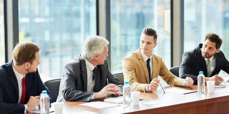 modern confident business executives in formal suits sitting at conference table and arguing at meeting while discussing company development FEATURED IMAGE