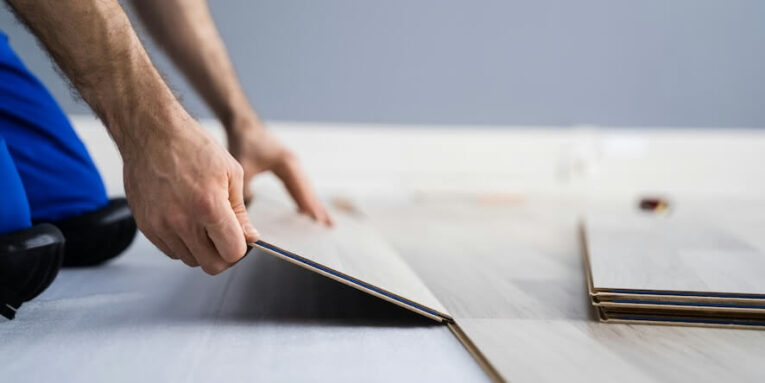 hardwood floor renovation construction worker doing new laminate installation FEATURED IMAGE