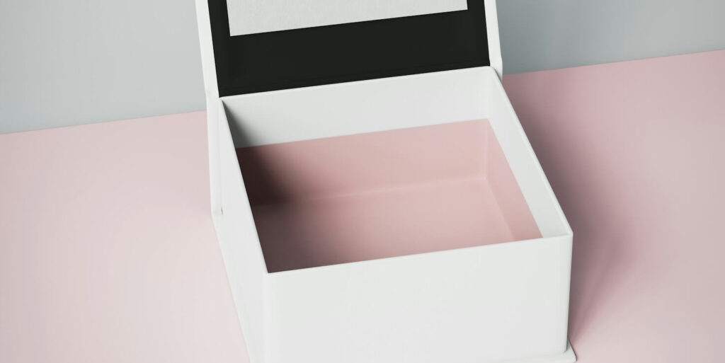 a white box with a black lid on a pink surface FEATURED IMAGE