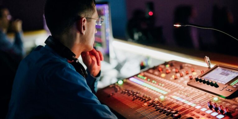 a man sitting in front of a sound board FEATURED IMAGE