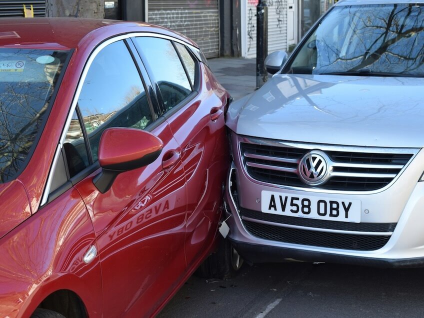 two cars parked next to each other in a parking lot