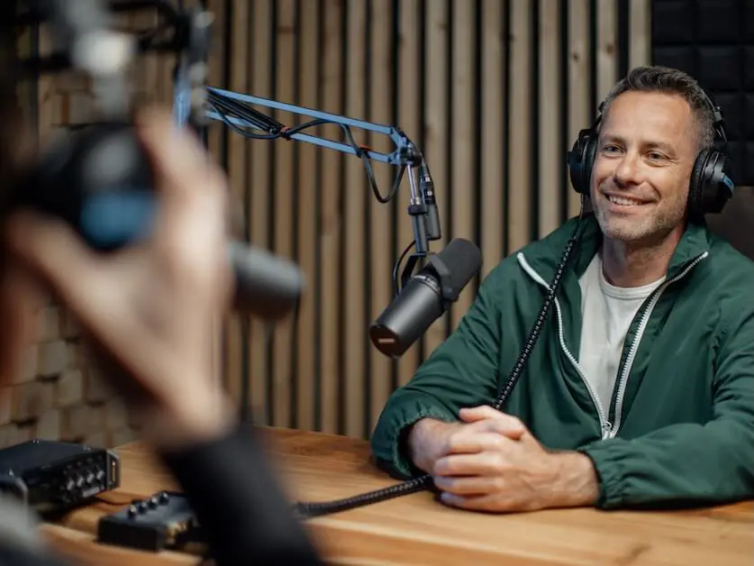 a man host talking to microphone and interviewing a man for a radio podcast