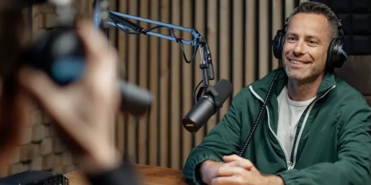 a man host talking to microphone and interviewing a man for a radio podcast FEATURED IMAGE