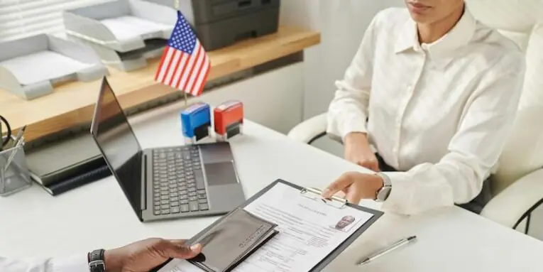 young specialist taking document from man to make visa in visa center FEATURED IMAGE