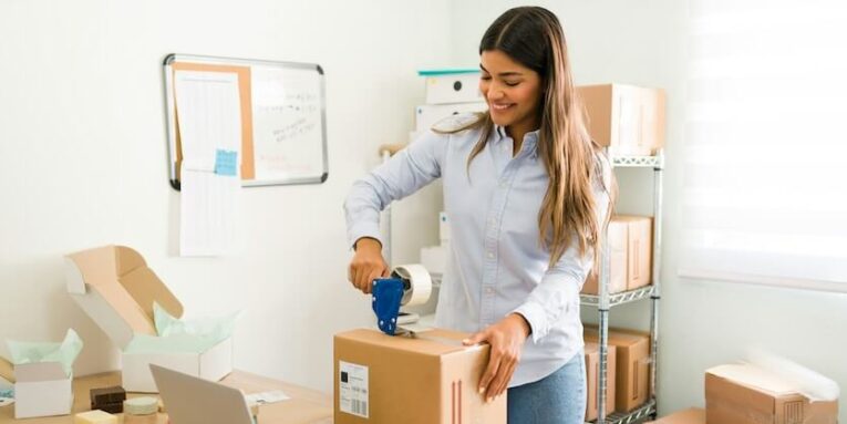 im feeling satisfied and proud with the growth of my business beautiful female entrepreneur putting tape on a package ready to ship to a customer FEATURED IMAGE