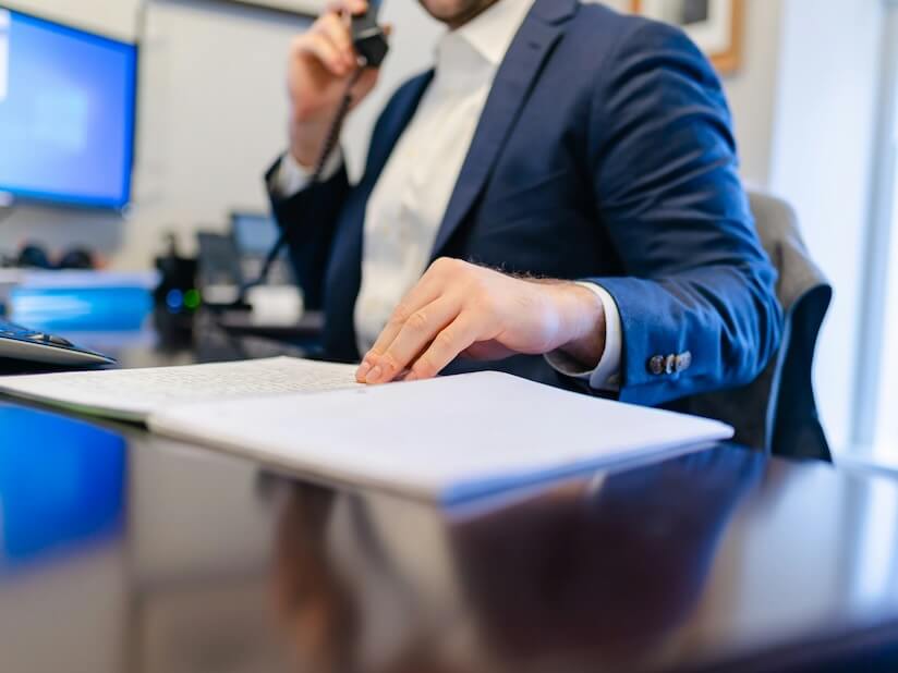 a man sitting at a desk writing on a piece of paper