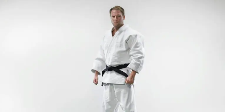 a man in a white kimono standing with his hands in his pockets FEATURED IMAGE