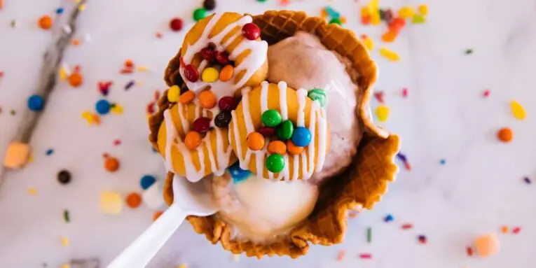 brown cone with white ice cream and sprinkles FEATURED IMAGE