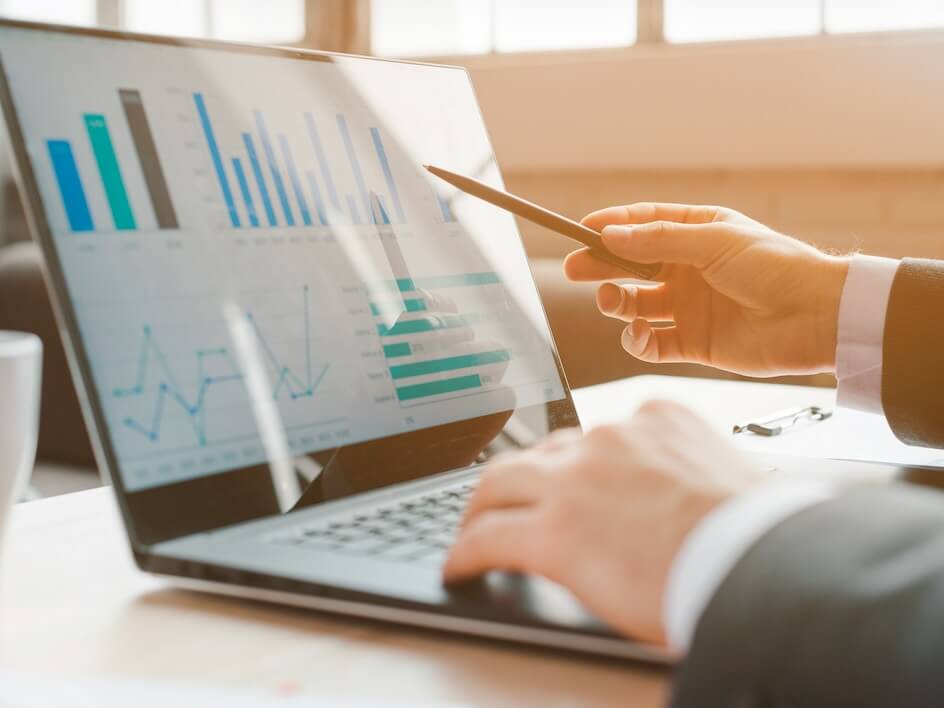 person analyzing business charts on laptop