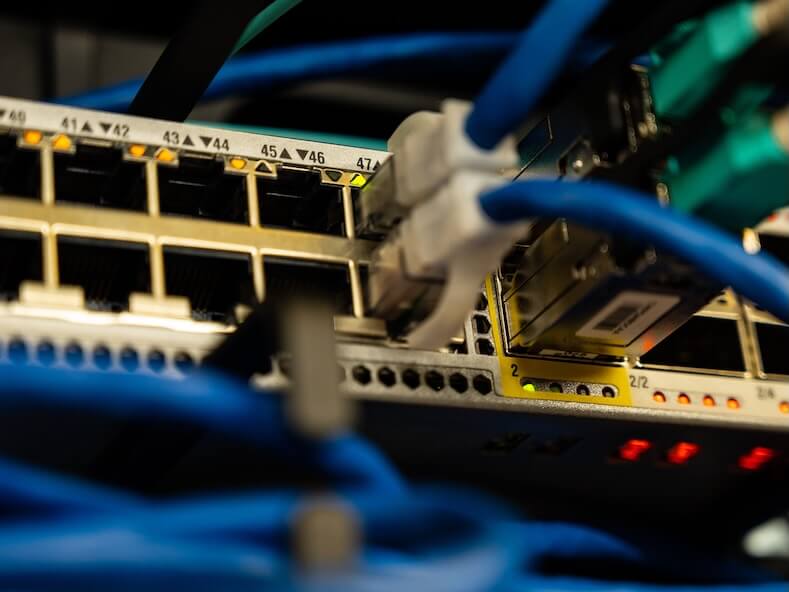 Close-up image of ethernet cables plugged into a network switch, showcasing IT infrastructure.